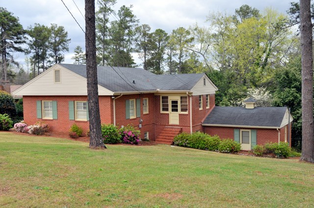 1709 Upper River Road Macon, GA 31211 - Photo 1 of 34 a front view of a house with a garden and yard