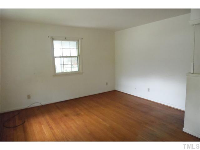 2909 Gladstone Drive Raleigh, NC 27610 - Photo 3 of 10 a view of an empty room with wooden floor and a window