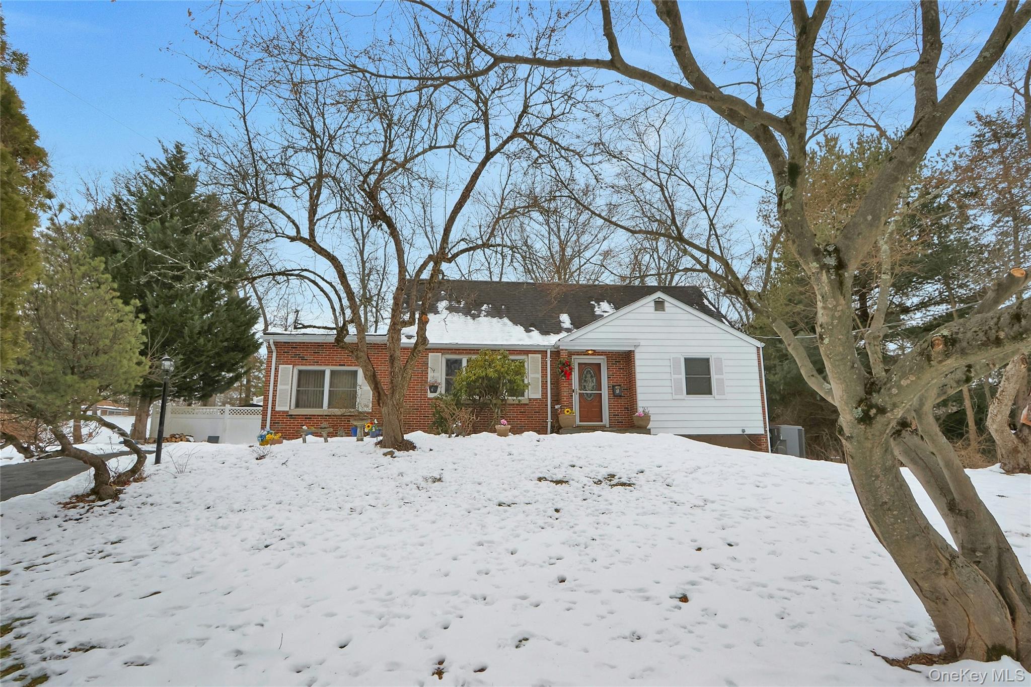 a front view of house with yard covered in snow