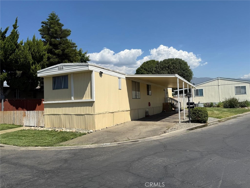 1350 San Bernardino Road, Unit 144 Upland, CA 91786 - Photo 4 of 17 a front view of a house with a yard and garage