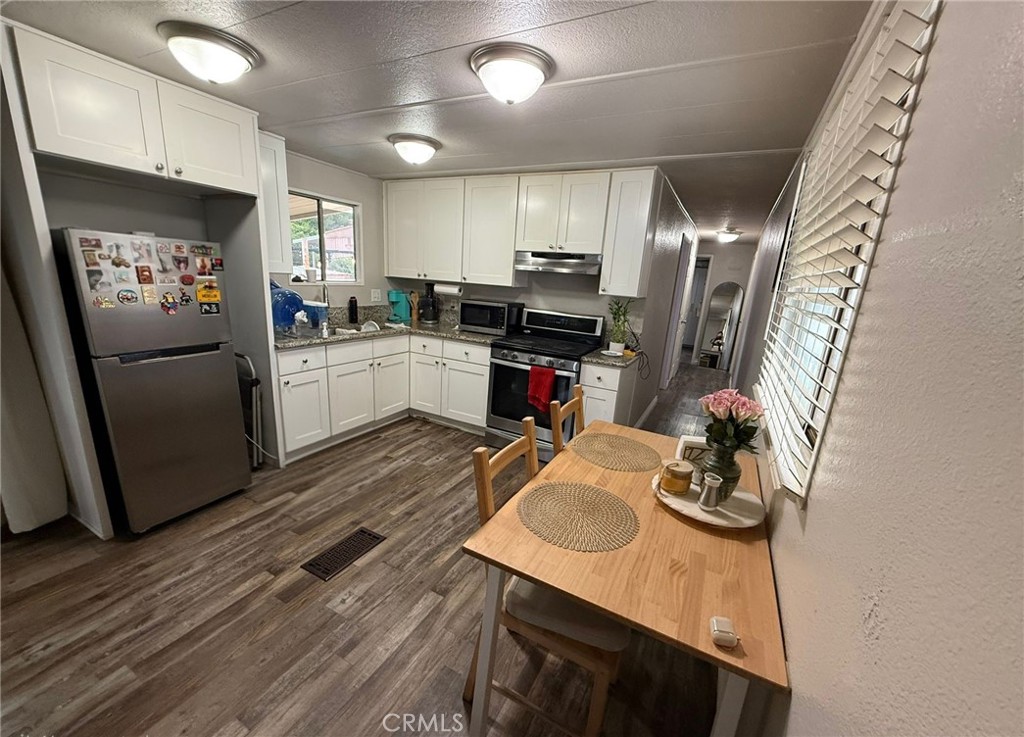 1350 San Bernardino Road, Unit 144 Upland, CA 91786 - Photo 10 of 17 a kitchen with sink cabinets and wooden floor