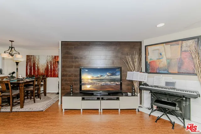 a living room with furniture a flat screen tv and kitchen view