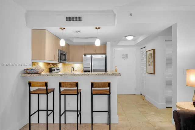 a kitchen with cabinets and chairs