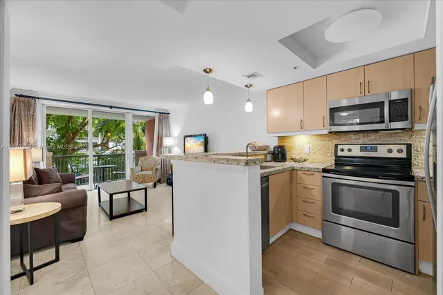 a kitchen with stainless steel appliances granite countertop a stove a sink and a microwave