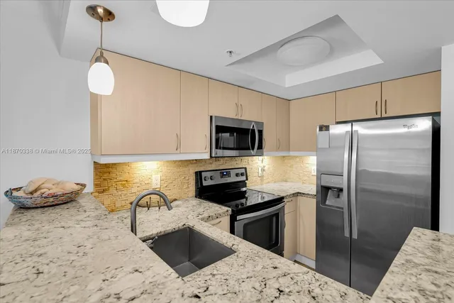 a kitchen with stainless steel appliances granite countertop a sink refrigerator and microwave