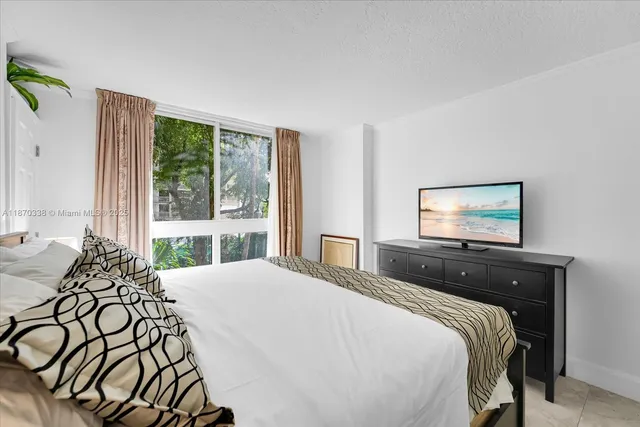 a bedroom with a bed and a large window