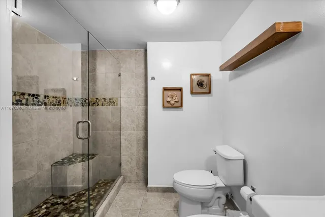 a bathroom with a toilet and a shower