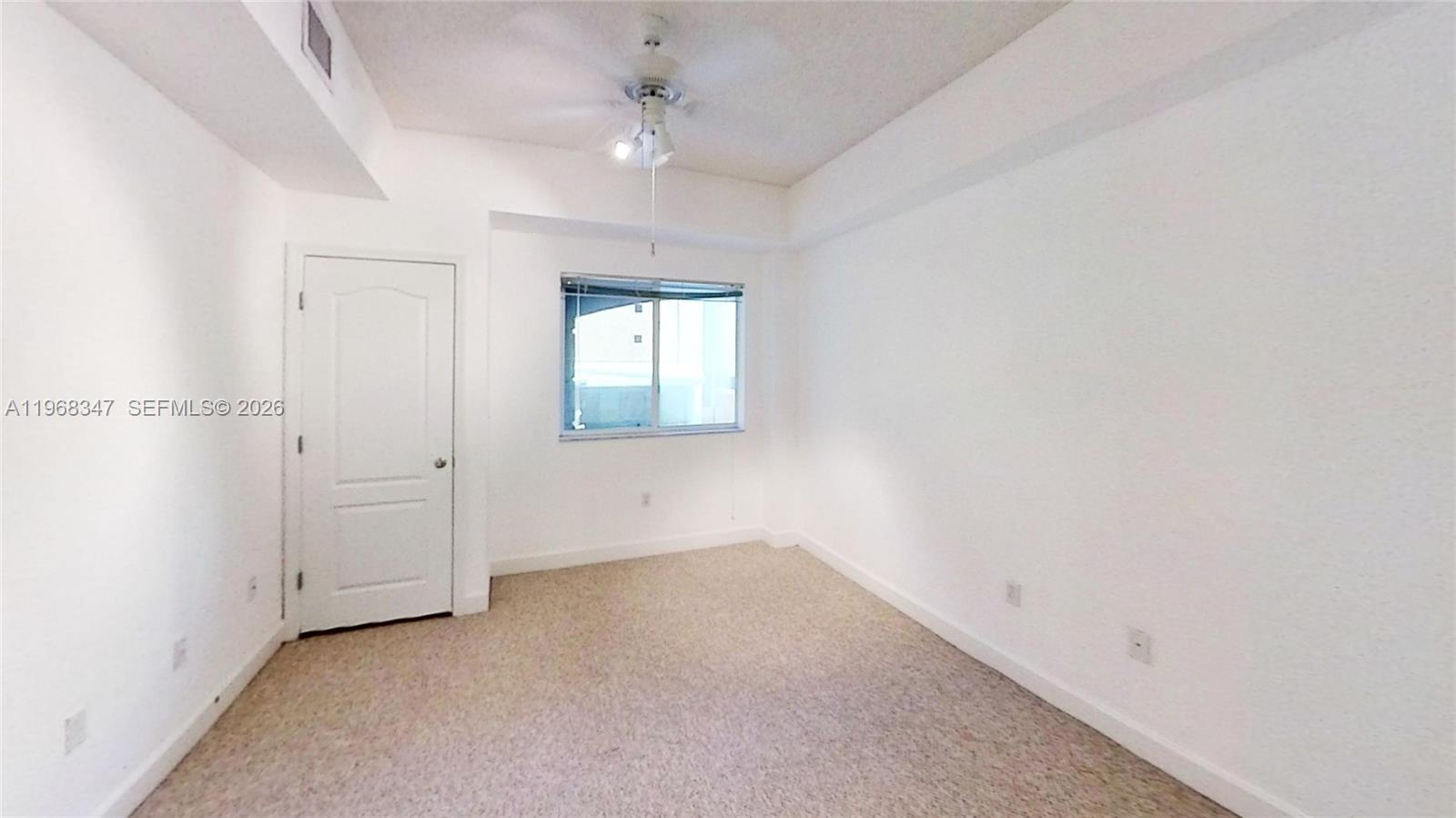 6001 Southwest 70th Street, Unit 217 South Miami, FL 33143 - Photo 12 of 21 an empty room with windows and fan