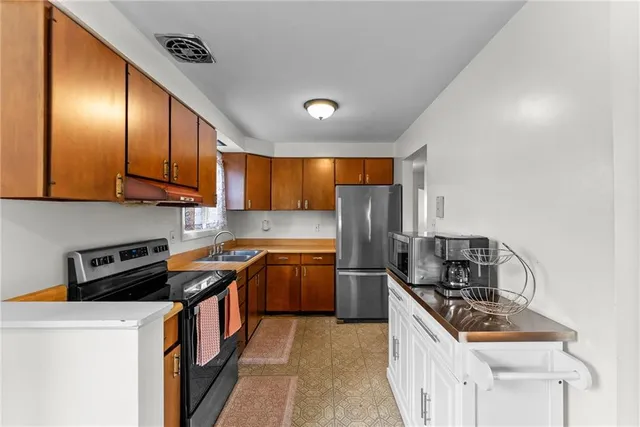 a kitchen with granite countertop stainless steel appliances and wooden cabinets
