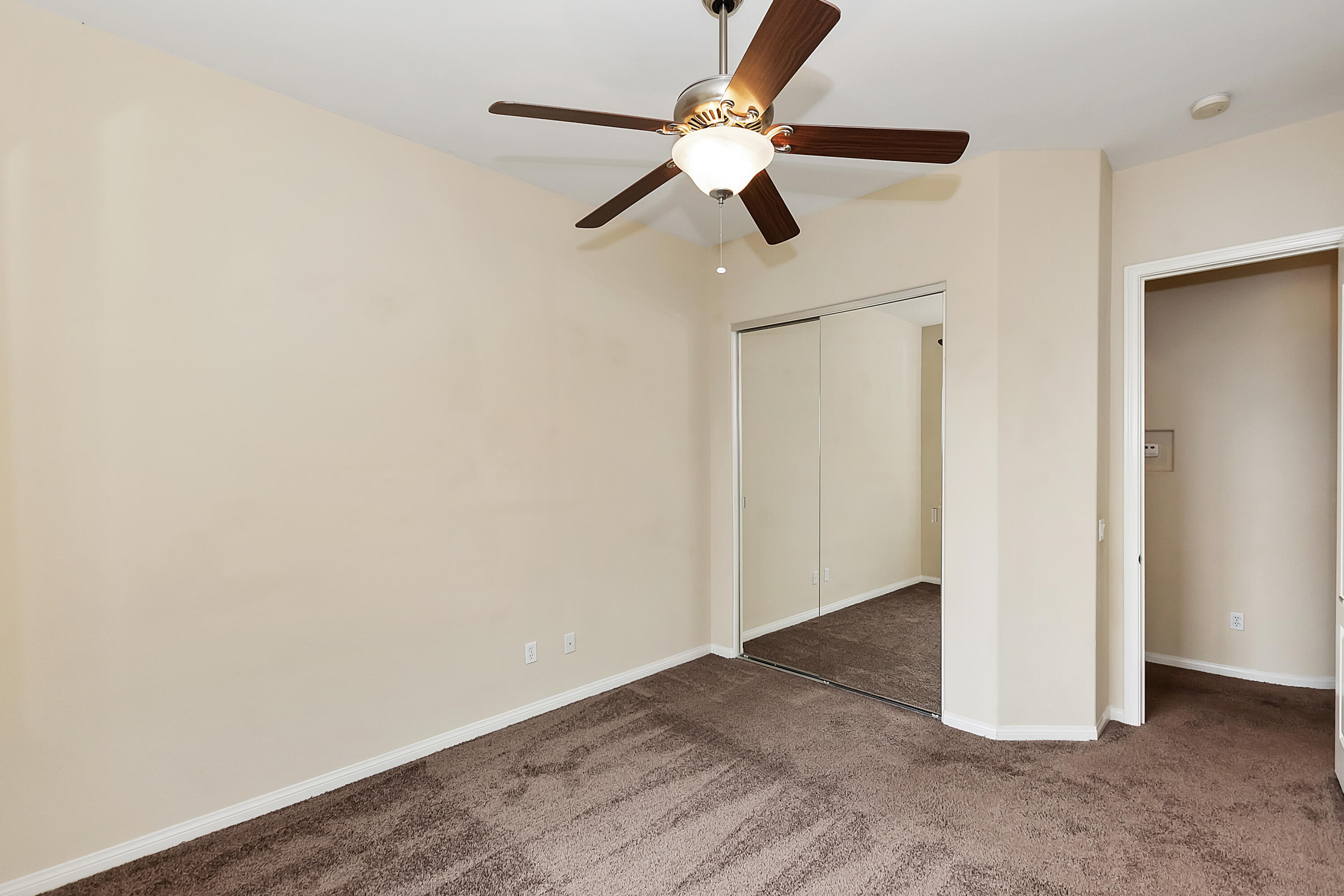 134 Via Tuscany Rancho Mirage, CA 92270 - Photo 23 of 44 an empty room with wooden floor ceiling fan