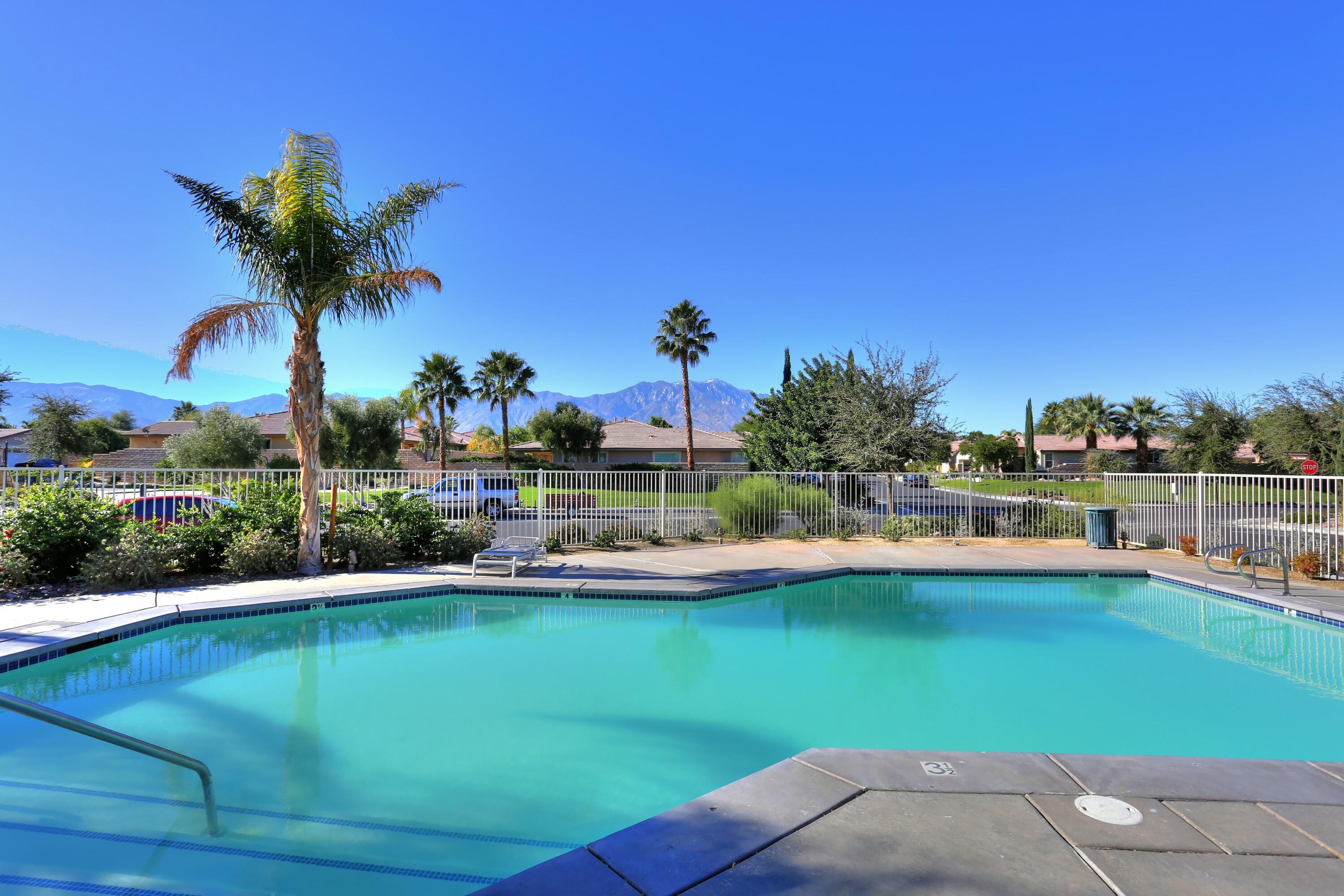 134 Via Tuscany Rancho Mirage, CA 92270 - Photo 44 of 44 a view of a swimming pool with a table and chairs under an umbrella