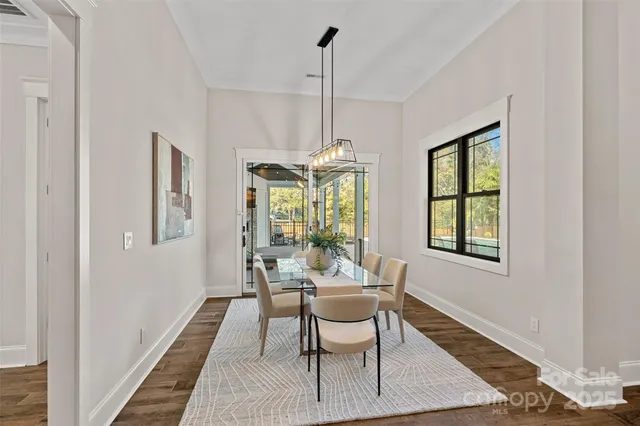 a dining room with furniture a chandelier and wooden floor