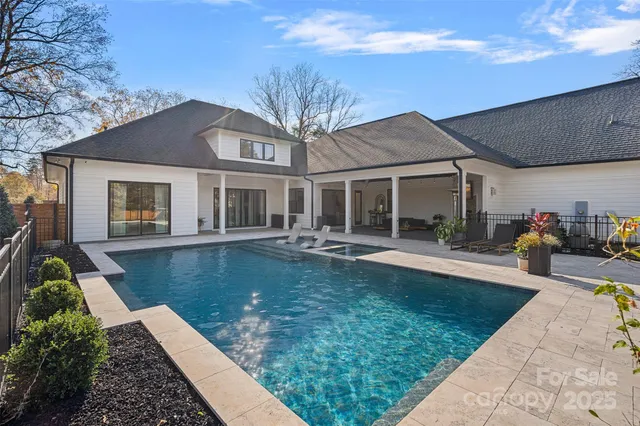 a view of a house with swimming pool and sitting area