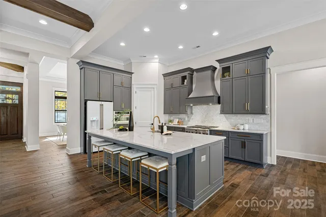 a large kitchen with stainless steel appliances granite countertop a lot of counter space and wooden floor