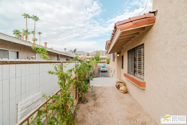 a front view of a house with a yard and potted plants