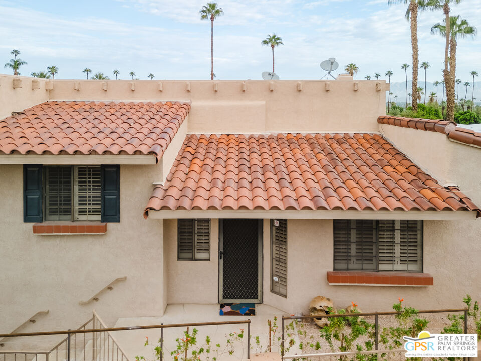 46400 Ryway Place, Unit 10 Palm Desert, CA 92260 - Photo 22 of 48 a front view of a house with a yard and garage