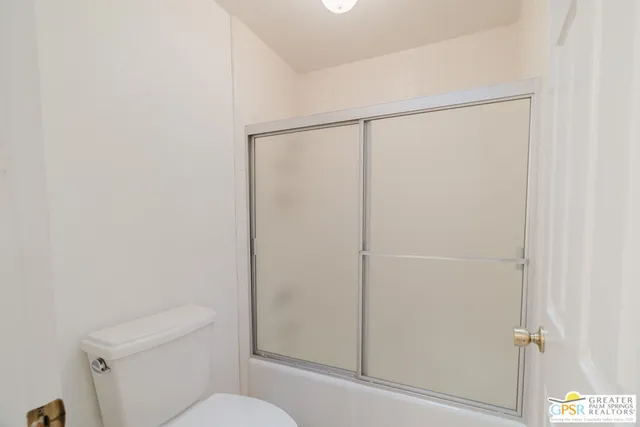 a bathroom with a shower a toilet and a sink