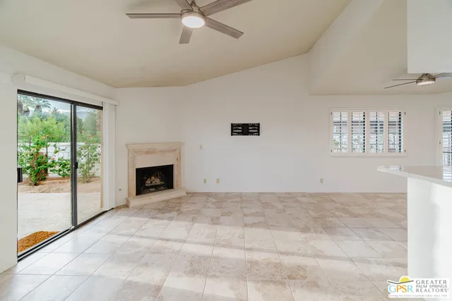 a view of empty room with fireplace and fan