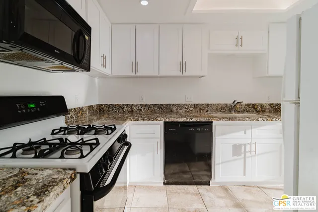 a kitchen with stainless steel appliances granite countertop a stove and a microwave
