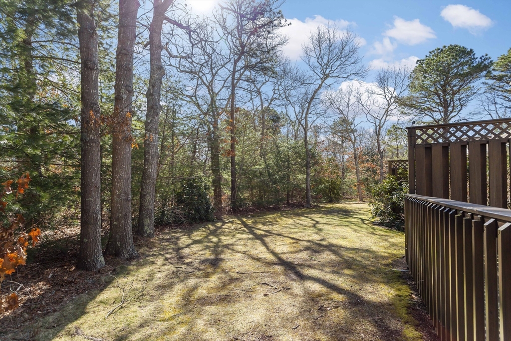 3 Kettle Lane, Unit 3 Mashpee, MA 02649 - Photo 19 of 24 a view of a yard with trees in the background