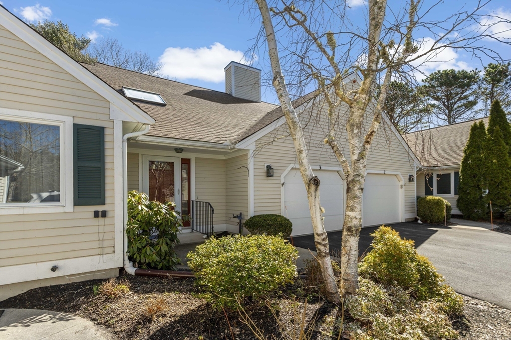 3 Kettle Lane, Unit 3 Mashpee, MA 02649 - Photo 2 of 24 a view of a white house with a flower garden