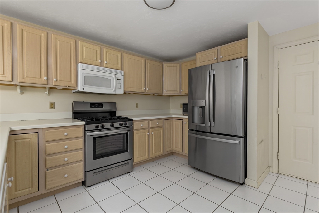 3 Kettle Lane, Unit 3 Mashpee, MA 02649 - Photo 6 of 24 a kitchen with stainless steel appliances granite countertop a refrigerator sink and cabinets