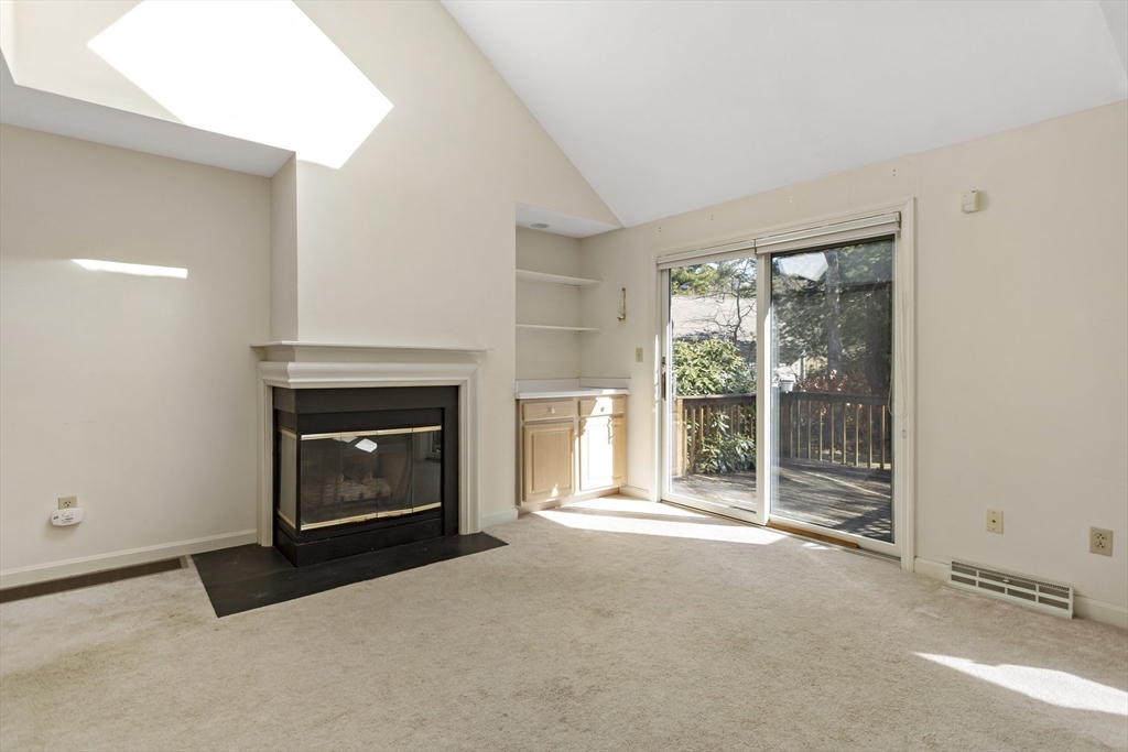 3 Kettle Lane, Unit 3 Mashpee, MA 02649 - Photo 8 of 24 a living room with a fireplace and a floor to ceiling window