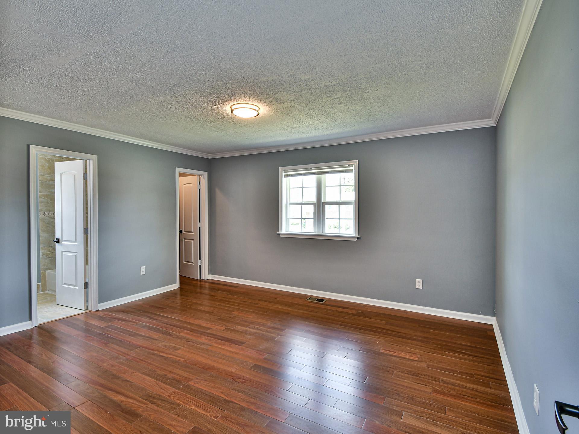 9303 Small Drive Clinton, MD 20735 - Photo 15 of 48 a view of an empty room with wooden floor and a window