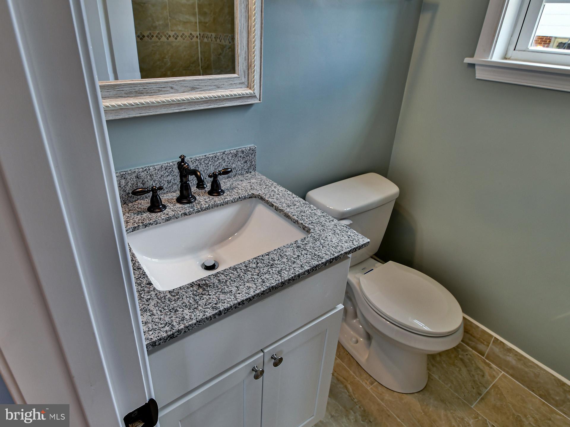 9303 Small Drive Clinton, MD 20735 - Photo 18 of 48 a bathroom with a granite countertop toilet sink and mirror