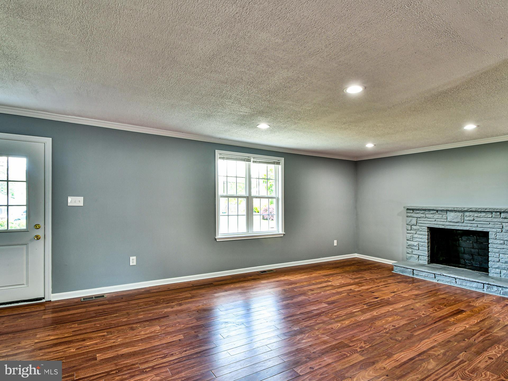 9303 Small Drive Clinton, MD 20735 - Photo 4 of 48 an empty room with wooden floor and fireplace