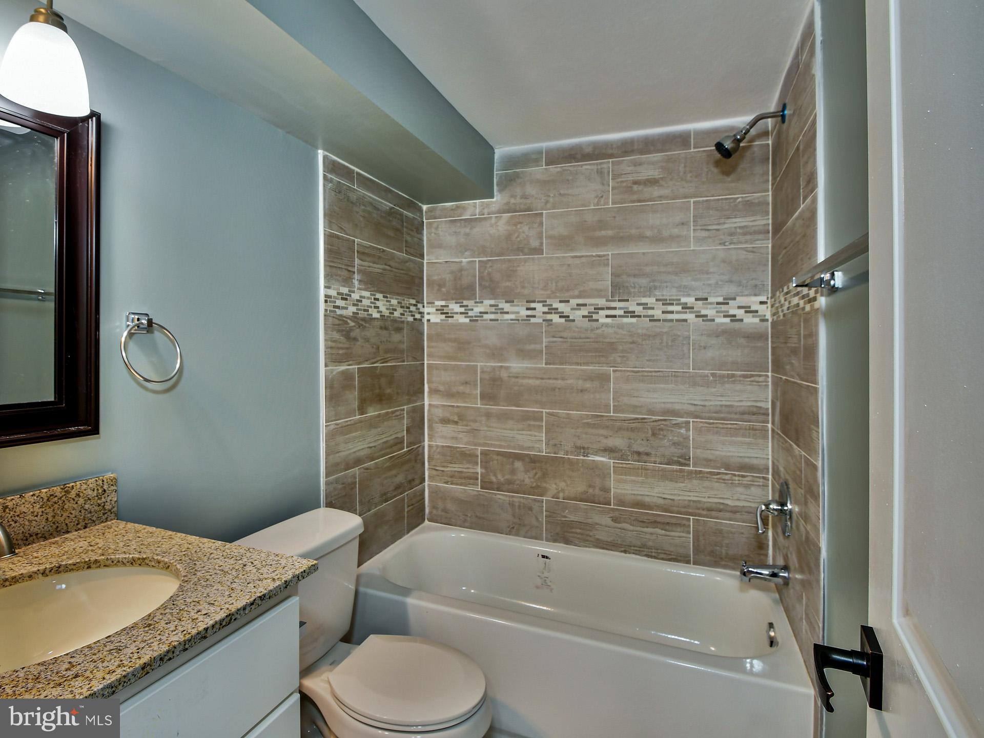 9303 Small Drive Clinton, MD 20735 - Photo 40 of 48 a bathroom with a granite countertop toilet sink and shower