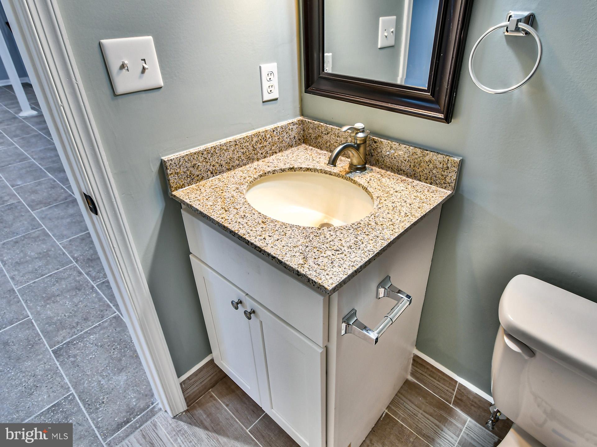 9303 Small Drive Clinton, MD 20735 - Photo 41 of 48 a bathroom with a granite countertop sink and a toilet