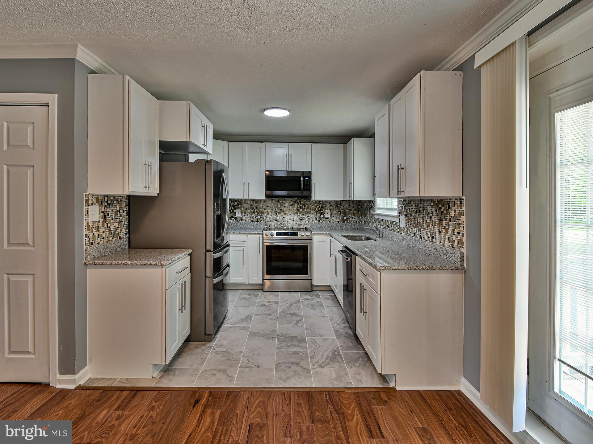 9303 Small Drive Clinton, MD 20735 - Photo 9 of 48 a kitchen with a refrigerator sink and cabinets