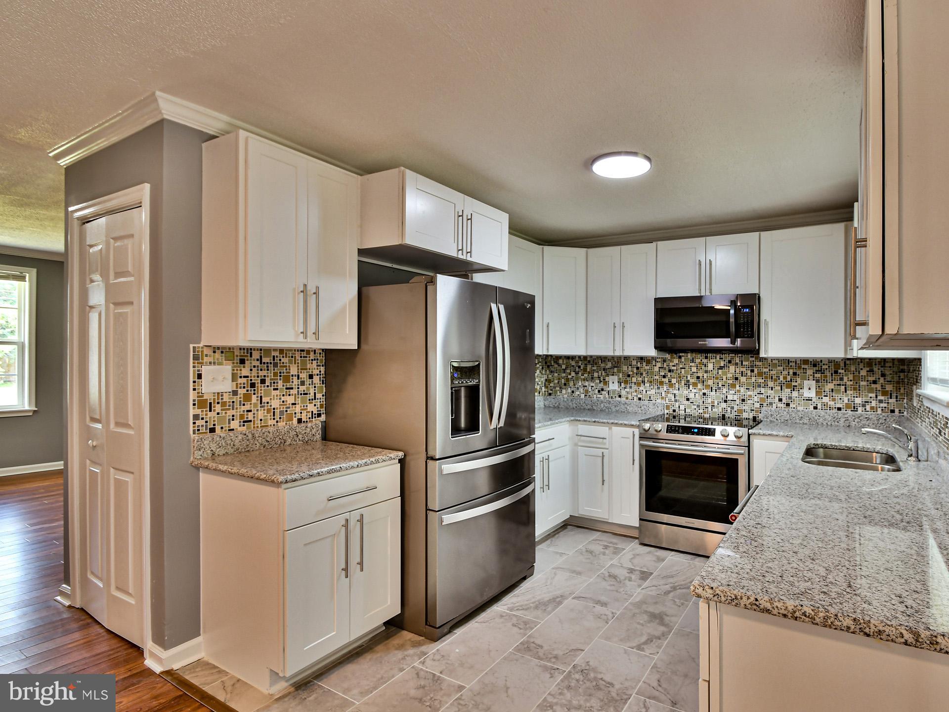 9303 Small Drive Clinton, MD 20735 - Photo 10 of 48 a kitchen with stainless steel appliances granite countertop a refrigerator stove a sink and dishwasher