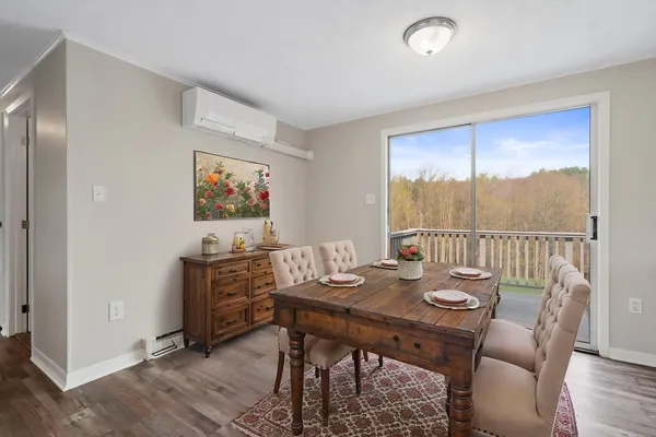 a view of a dining room with furniture wooden floor and painting on the wall