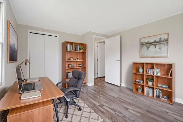 a view of a workspace with furniture and a bookshelf