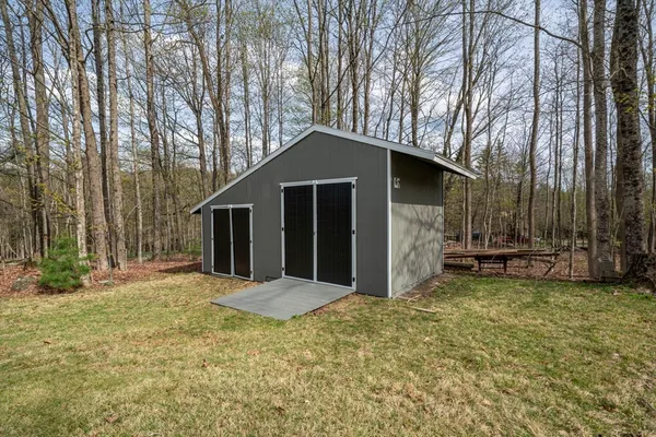 a view of a house with backyard and trees