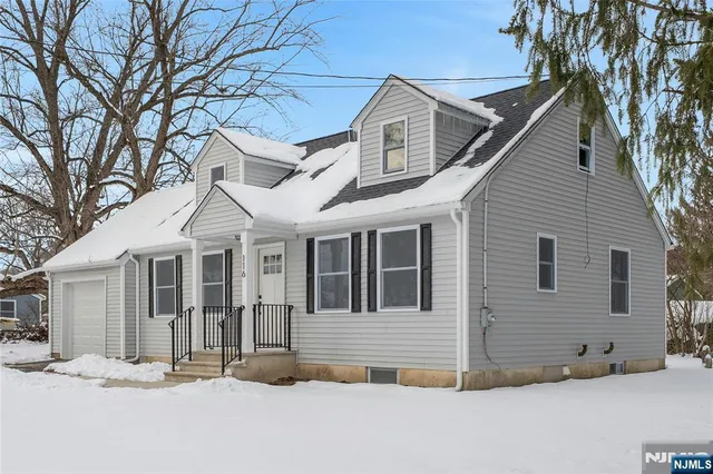 a front view of a house with a tree