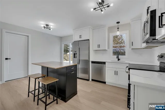 a kitchen with a table chairs refrigerator and cabinets