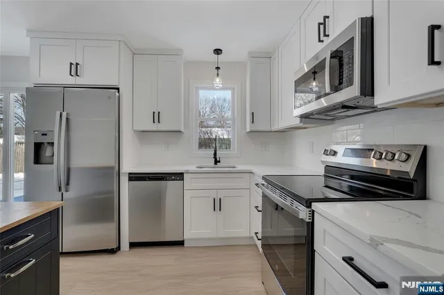 a kitchen with white cabinets and stainless steel appliances