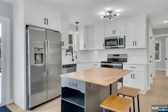 a kitchen with stainless steel appliances a stove a refrigerator and a sink