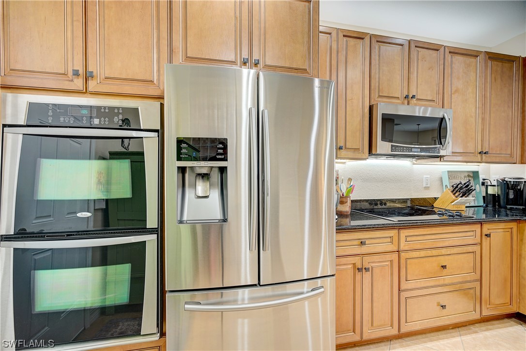 4089 Cherrybrook Loop Fort Myers, FL 33966 - Photo 7 of 35 a kitchen with granite countertop a refrigerator and a stove top oven