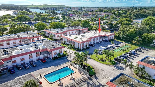 an aerial view of a city with lots of residential buildings ocean and mountain view in back