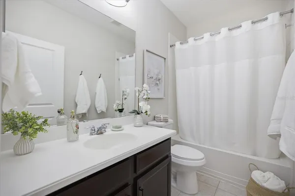 a bathroom with a sink a toilet and shower curtain