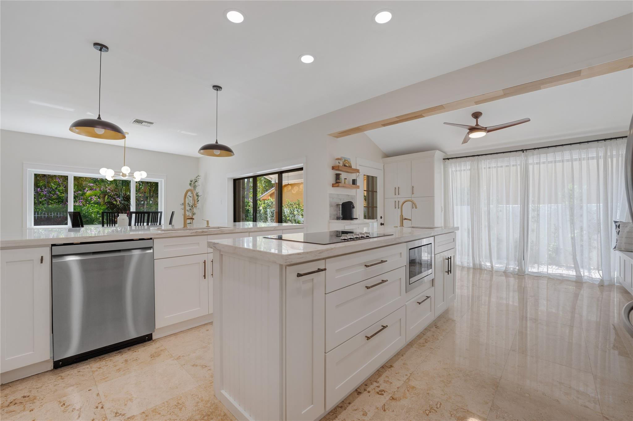 741 Mockingbird Lane Plantation, FL 33324 - Photo 6 of 59 a kitchen with kitchen island white cabinets and white appliances