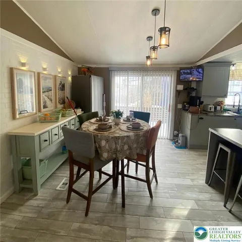 a dining hall with stainless steel appliances granite countertop a sink a stove a dining table and chairs