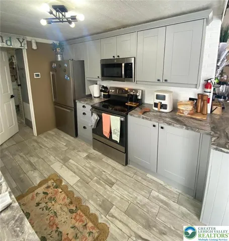 a kitchen with stainless steel appliances granite countertop a refrigerator stove top oven and sink