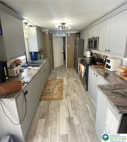 a large white kitchen with a stove a sink dishwasher and a oven
