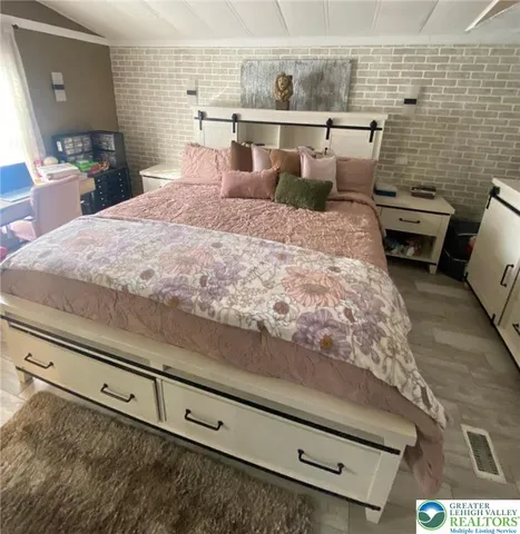 a bed sitting in a bedroom and chair