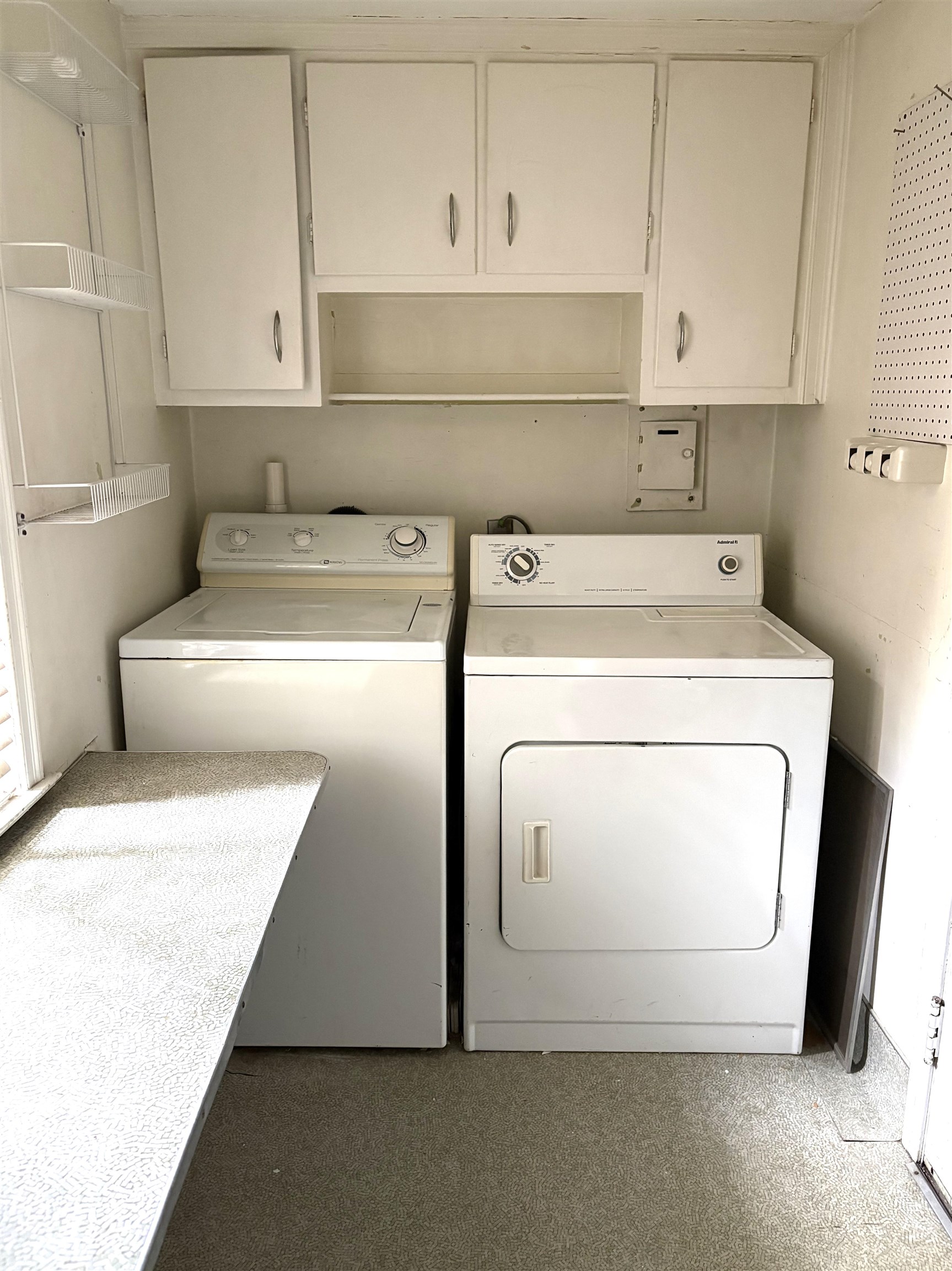 Dedicated laundry area featuring upper cabinetry, an open shelf, and built-in shelving